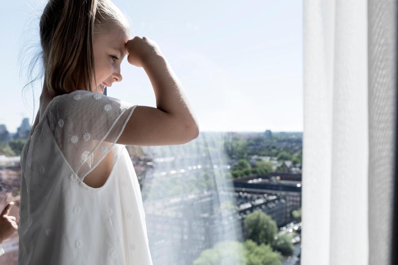 Hotel Okura Amsterdam - The Leading Hotels Of The World Extérieur photo A girl looking out of a window