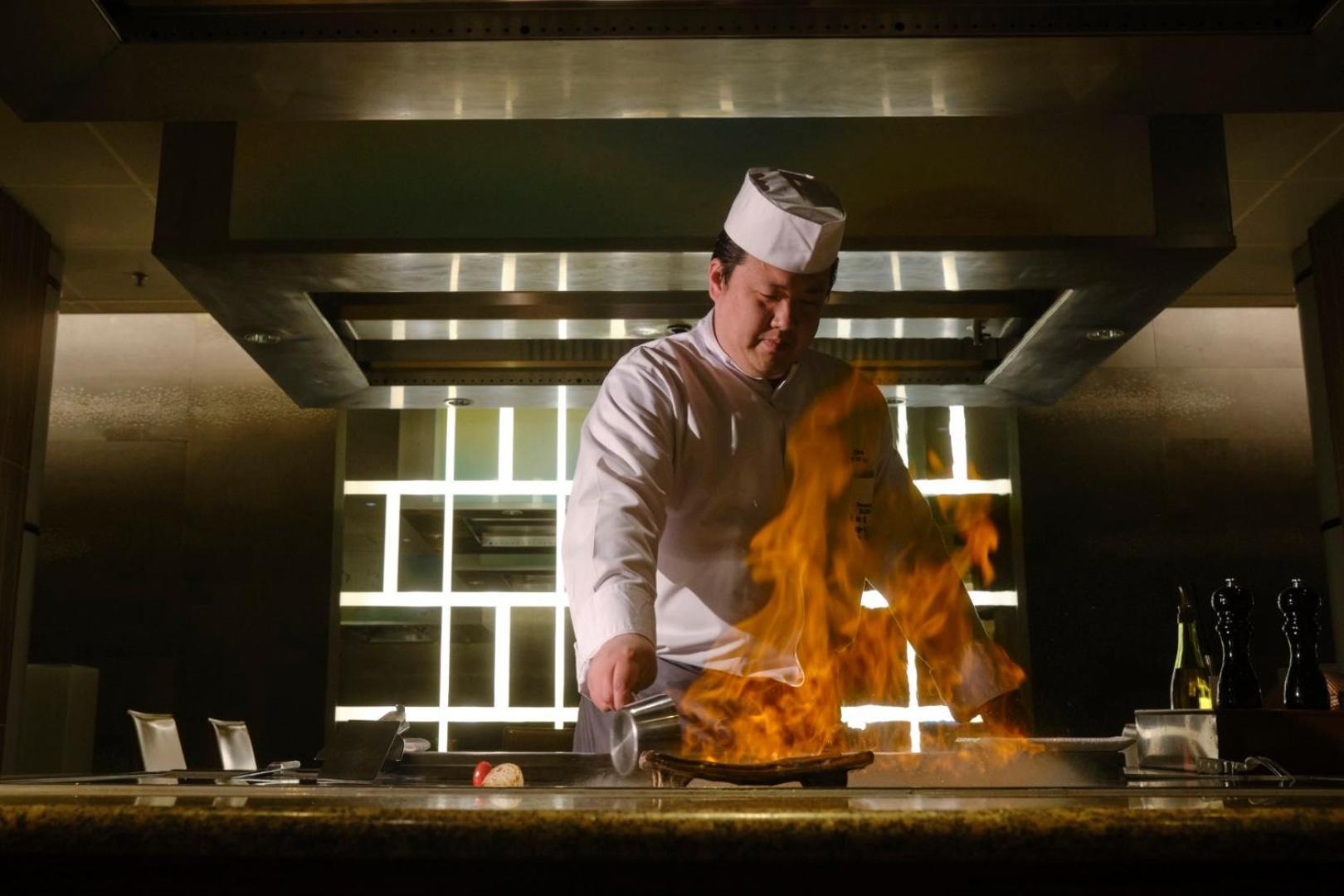 Hotel Okura Amsterdam - The Leading Hotels Of The World Extérieur photo A chef cooking with a flaming wok